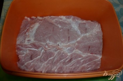 Берем приличный кусочек свинины (без кости и попостнее), промываем, промокаем салфетками. Чеснок чистим и измельчаем любым удобным способом. Укладываем свинину в ёмкость с крышкой, в нескольких местах протыкаем ножом.