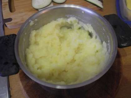 С картофеля слить воду, добавить молоко и сливочное масло. Тщательно перемешать, чтобы не образовалось комочков