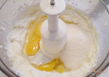 Когда масса творожная станет по консистенции как сметана, тогда добавьте яйца и сахар, и продолжайте взбивать.
