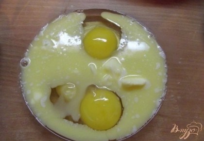 Вбейте в миску два куриных яйца и влейте туда сливочное масло. При этом масло должно быть обязательно остывшее к этому моменту иначе яйца могут слегка схватится и быть комками, потеряв свои свойства.