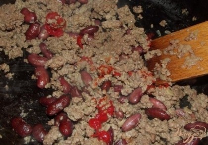 Когда мясо побелеет и фасоль будет почти готова. кладите томатную пасту, хорошенько перемешивайте, солите и перчите по вкусу, накрывайте крышкой и доводите до готовности.