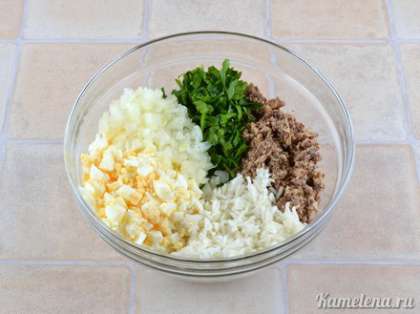 К сайре добавить рис, лук, яйца, петрушку. Немного посолить, добавить сметану (или майонез), хорошо перемешать.