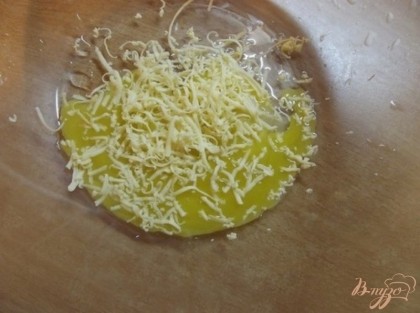 Сверху на яйцо натрите сыр на мелкой терке. Для этого блюду нужно использовать исключительно твердый сыр по типу пармезана. К слову, чем более "Пахучий" сыр, тем вкуснее будет кляр.