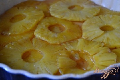 Форму смазать сливочным маслом , выложить карамелизированные кружочки  ананаса и полить оставшейся карамелью. Оставить на 1 час.