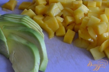 Половинку манго нарезать на кубики. Авокадо разрезать на две части, вынуть косточку и нарезать на тонкие ломтики.