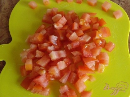 Берем один среднего размера свежий помидор. Хорошо промываем под проточной водой и нарезаем кубиками. Размер и вид нарезки выбираем произвольно. Но более мелкая нарезка помидора кубиками лучше подходит для этого омлета, получается вкуснее.