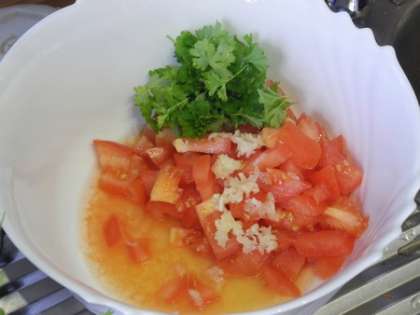 Нарезать в салатницу помидоры, петрушку и чеснок. Заправить соком лимона и оливковым маслом