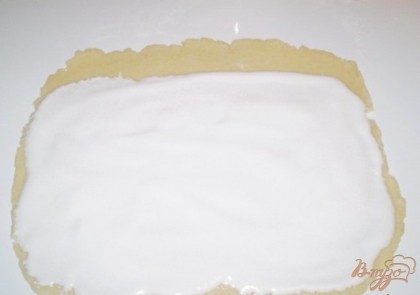 Тесто раскатываем в прямоугольник. Сверху распределяем белки с сахаром.