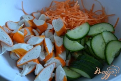 В салатнике смешать морковь (натереть тонко) , огурцы и крабовые палочки.