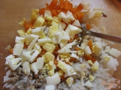 Отварите морковь и яйца в крутую. Нарежьте кубиками и положите в салат.