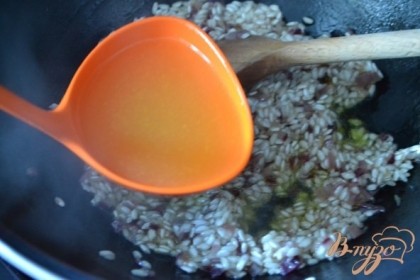 Затем вливаем бульон небольшими порциями. Немного бульона, ждем пока жидкости не станет, добавляем еще. И так до полного приготовления риса. Огонь тихий.