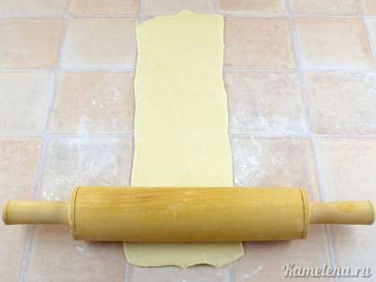 Тесто предварительно разморозить, стол немного подпылить мукой. Раскатать тесто в длину до 3-4 мм по толщине (раскатывать в одном направлении).