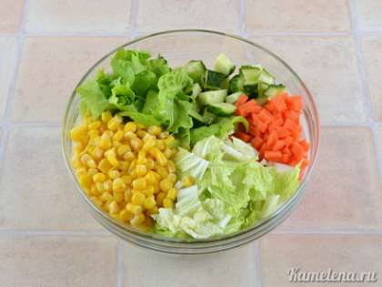 В салатник положить капусту, огурцы, морковь, кукурузу, салатные листья. Посолить, добавить растительное масло, хорошо перемешать.