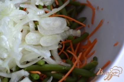 В салатник выложить отварную фасоль, морковь (натереть тонко), выдавить чеснок через пресс  и репчатый лук. Нагреть оливковое масло до легкого дымка и вылить в миску с овощами.Хорошо перемешать.