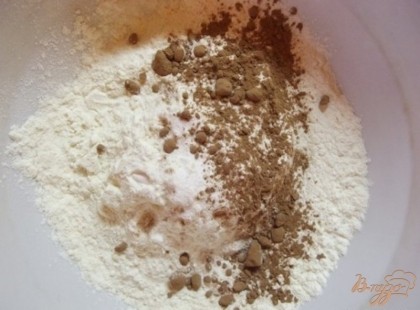 В отдельной миске смешайте муку и полную чайную ложку (без горки) соды. Добавьте также щепотку соли. Кроме того всыпьте две столовые ложки какао и перемешайте.