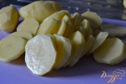 Картофель почистить и нарезать на кружочки. Для того, что бы запеканка приготовилась в два раза быстрее, картофель сначала отвариваем в течении 3-5 мин.