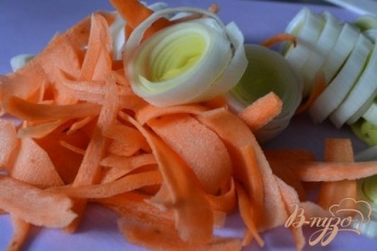 Порей нарезать, морковь настрогать ножом экономкой.Обжарить в течении 5 мин. на сковороде с оливковым и сливочным маслом.