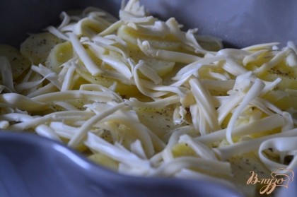 Посыпать половиной нормы сыра. Затем выложить еще слой картофеля.