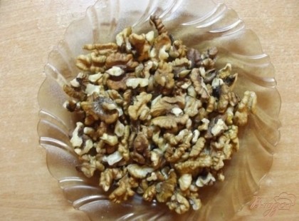 Грецкие орехи подавите в кулачке так, чтобы они поломались на крупные кусочки. И отдельно добавьте несколько крупных орехов, для украшения.