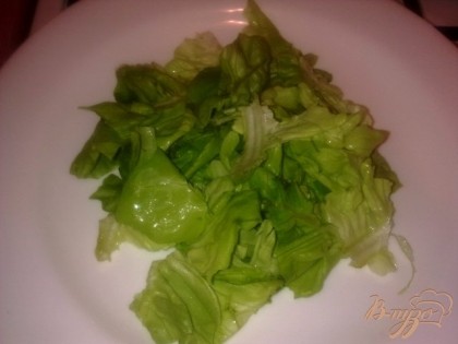 На порционную тарелку кладем салатные листья и сбрызгиваем лимонным соком