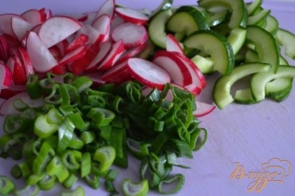 Огурец разрезать вдоль и вынуть середину. Так салат не будет водянистый.Редис, зеленый лук и половинки огурца нарезать на кусочки.