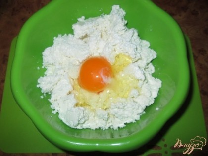 В глубокую миску положим творог и разобьем одно яйцо.