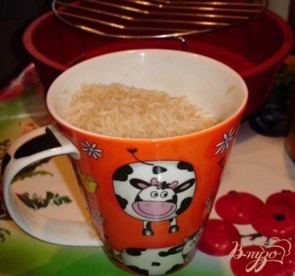 Наполните 1 чашку сырым рисом (в чашке 300 гр). Рис промойте, дайте стечь воде и высыпьте рис в форму.