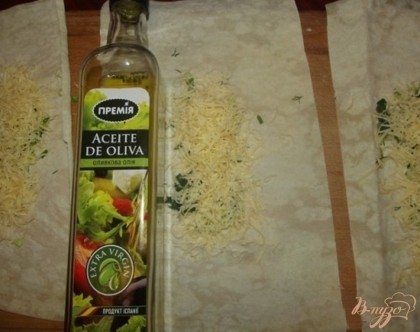 Оливковое масло наливаем прямо на сыр, примерно одну чайную ложку. Кроме того смазываем им края лаваша, а можно и весь лаваш.