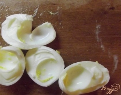Когда куриные яйца сварятся, сразу же опустите их в холодную воду. Таким образом их легче будет чистить. Отделите у них белок от желтка.