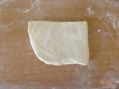 Складываем тесто пополам к себе. После этого снова смазываем маслом и складываем его вправо от себя пополам. Сложенное тесто сверху присыпаем мукой и раскатываем тонко но не тоньше 0,5 см. Его раскатывать будет сложно.