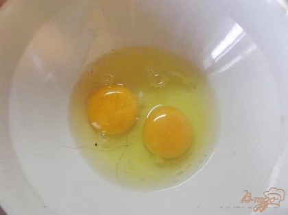 Для начала вам необходимо в глубокую миску вбить два куриных яйца.