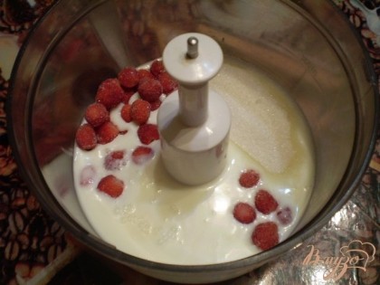 В готовый йогурт добавляем сахар и ягоды земляники. Сахар желательно заменить на мед. Пюрируем массу.