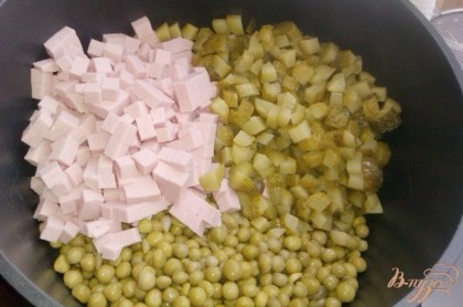 Огурцы и колбасу режем кубиками, складываем в посудину, добавляем горошек.
