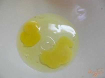 Вбейте в миску два куриных яйца.