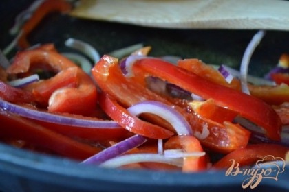 Сладкий перец и луковицу нарезать тонко и обжарить на оливковом масле в течении 5 мин.