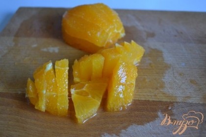 С апельсина срезать кожуру. Мякоть нарезать на кусочки.