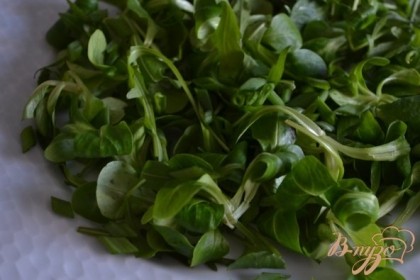 По тарелкам разложить салатные листья и посыпать зеленым луком.