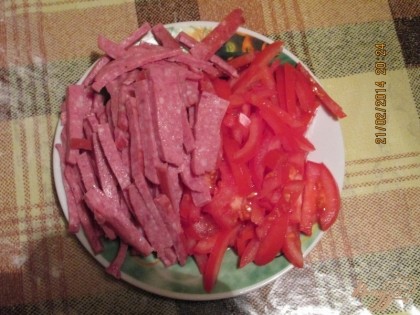 Нарежьте колбасу и помидоры соломкой.