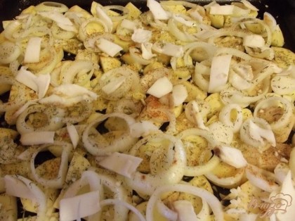 Лист для выпекания смажьте растительным маслом и выложите в один слой картофель, сверху лук. Поверх лука посолите картофель и посыпьте специями. Сало нарезаем как можно тоньше. Раскладываем его равномерно на картофель. Отправляем картофель в разогретую до 200 градусов духовку.