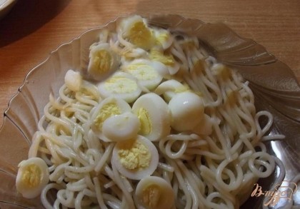 Перепелиные яйца необходимо отварить в крутую (это примерно 5-7 минут). Варятся они немного быстрее, чем куриные за счет своего небольшого размера. Дальше их нужно очистить от скорлупы и нарезать кружочками. Готовые спагетти откиньте на дуршлаг, потом назад в кастрюльку. Заправьте сливочным маслом. Разложите спагетти по тарелкам и положите к ним нарезанные яйца. Перемешайте.