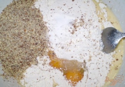 Орехи измельчаем в крошку. Соединяем кефирно-масляную смесь и орехи (часть орехов отберите для обсыпки готового кекса), яйца (1яйцо целое+желток второго яйца), ванилин, разрыхлитель для теста, муку. Вымешиваем ложкой тесто до однородности.