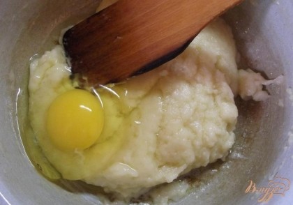 Через 5 минут вбейте одно куриное яйцо и при помощи ложки или деревянной лопатки замесите тесто. Замешивайте тесто до тех пор, пока оно не станет однородным. На это может уйти от 2 до 5 минут. Дальше всыпьте сахарную пудру и повторите процедуру. Второе яйцо взболтайте в отдельной миске и подливайте понемногу. Может понадобится только половина.
