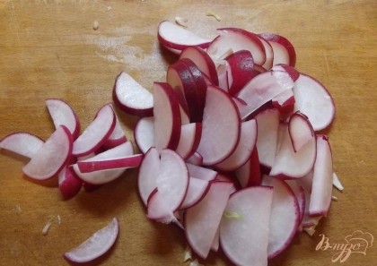 Для начала тонкой соломкой порежьте капусту. Редиску в салат нарезайте не мелко, чтобы ее удобно было брать вилкой.