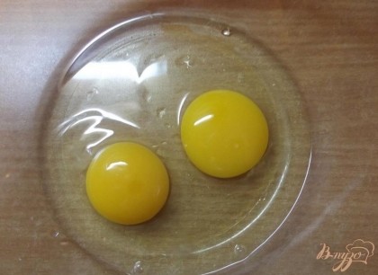 В глубокую миску вбейте два куриных яйца. Если яйца у вас небольшого размера с маленьким желтком то используйте 2 яйца и дополнительно один желток.
