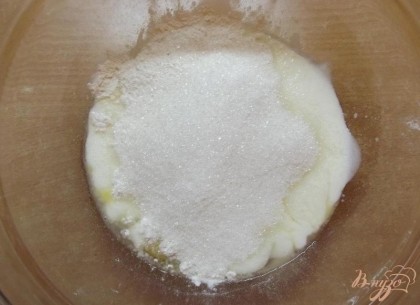  Половину просеянной муки, а также сахар введите в тесто и перемешайте ложкой. После введите оставшуюся муку и миксером на медленной скорости перемешайте тесто до однородного состояния. Мешайте как можно дольше, чтобы тесто стало воздушным.