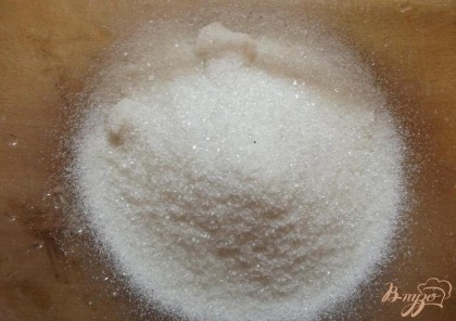 Сначала достаньте из холодильника сливочное масло и дайте ему подтаять. Дальше нарежьте его пластинками отложив 1 ч.л. для смазывания формы. На сильном огне нагрейте металлическую посуду. Снимите емкость с огня и положите в нее сливочное масло чтобы оно растаяло. В глубокую миску всыпьте весь сахар. Сахар для этого пирога можно использовать и тростниковый.