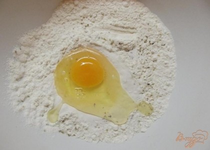 Смешайте муку с разрыхлителем, солью (1 ч.л.), содой, орегано и базиликом. Вбейте одно куриное яйцо и понемногу подливая простоквашу замешайте тесто мягкое.