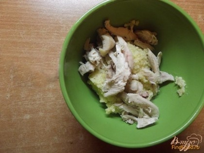 В порционные мисочки разложите куриное мясо и готовую пшенную крупу.