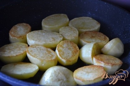 В глубокой сковороде на оливковом масле обжарить с обеих сторон крупные кусочки  сырого картофеля.