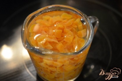 Порежем абрикос сушеный без косточек мелко. Зальем в емкости его горячей водой,чтоб он слегка распарился.